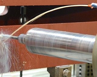 Jeff Lange | The Vindicator  A horizontal boring mill sprays down the drill as it bores a hole into the side of a large piece of metal.