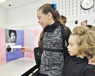Jeff Lange | The Vindicator  5 grader at Williamson Elementary Amerie Quinones (center) age 11 teaches 5 year old Gedalys Rodriguez (right) about the life of Michael Jackson, Friday morning during the Living History Museum at Williamson Elementary School in Youngstown.