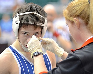 Jeff Lange | The Vindicator  Jackson Milton's Mitch Tikkanen has his face bandaged by during his preliminary round Division III matchup in Columbus during the 2015 state wrestling tournament.