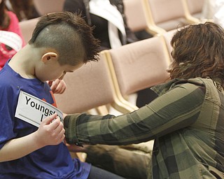       .         ROBERT  K. YOSAY | THE VINDICATOR..Sash time as Luke Martinucci from Youngstown Christian/Lewis School gets help from his mom Amy...The 82nd Regional Spelling Bee at Kilcawley Room at YSU .saw a repeat from last year as Annabelle Day bested over 50 other spellers Saturday Morning....-30-