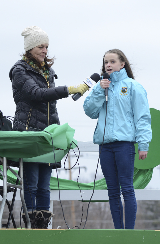 Katie Rickman | The Vindicator.Gemma Kearns, originally from Ireland but currently residing in Struthers,  sings the Irish National Anthem in Gaelic as the St. Patrick's Day Parade kicked off in Boardman on March 15, 2015. Casey Malone holds the mic up for her.