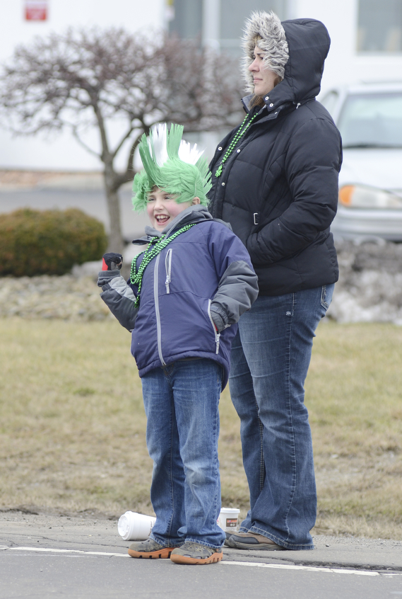Katie Rickman | The Vindicator.Ryan Bulford 7 of Leetonia motions for a parade participant to honk its horn as it passes by, his mother Christina stand behind him watching the parade pass on March 15, 2015.