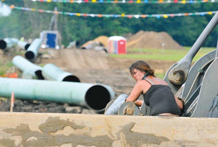 A protester from the Michigan Coalition Against Tar Sands group is locked to
heavy equipment at an Enbridge pipeline construction site near Stockbridge, Mich. The group fought the project, saying Enbridge should not be able to expand the capacity of its old pipeline and raising fear of pipeline leaks. The Michigan Public Service Commission ruled the project and route, which replaced an old pipeline that had spilled, were acceptable. AP file photo, July 22, 2013  Lansing State Journal

