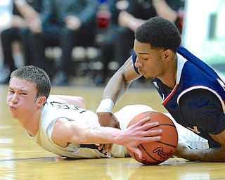 Jeff Lange | The Vindicator  Kennedy's A.J. Grant (right) battles for the ball with Aquinas defender Daniel Piero on the floor during late second half action of their game in Canton, Tuesday night. Warren fell to Aquinas 61 to 51.