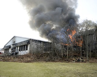 Katie Rickman | The Vindicator.A fire spreads from Asphalt Solution to an abandoned house as seen from Hughes Ave. on March 19, 2015.