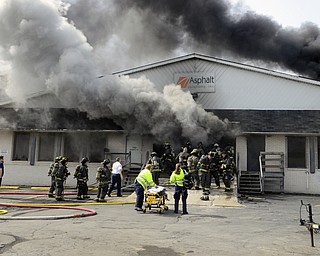 Katie Rickman | The Vindicator.Paramedics rush to the scene of the fire when a Youngstown Firefighter was pulled from the building due to smoke inhalation at Asphalt Solutions on March 19, 2015. The firefighter waved them away and walked away unharmed.