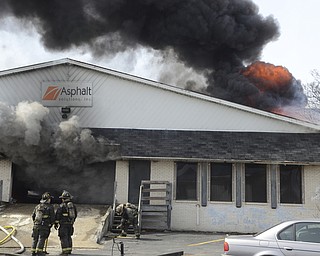 Katie Rickman | The Vindicator.Youngstown Firefighters survey the fire at Asphalt Solutions on on Market St. March 19, 2015.