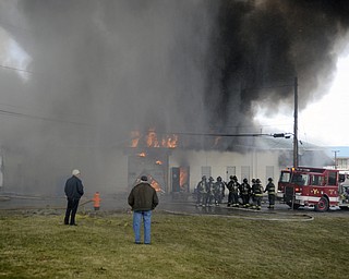 Katie Rickman | The Vindicator.A man watches as Youngstown Firefighters work to put out a fire at Asphalt Solutions on March 19, 2015.