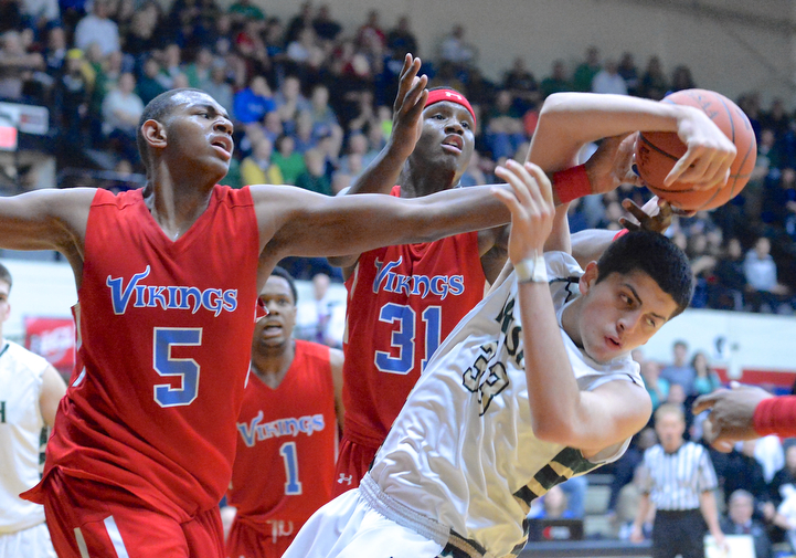 Jeff Lange | The Vindicator  Ursuline's Armon Nasseri (33) falls as he battles for possession with Vikings' defenders Derek Pardon (5) and Carlton Bragg (31) in the third quarter of their DIII regional final game, Saturday night in Canton. The Irish fell to VASJ 66 to 45.