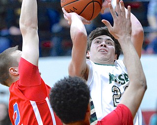 Jeff Lange | The Vindicator  Greg Parella of Ursuline (right) looks over the defense of Jeff Grudzinski (left) and Tre'von Williams-Scruggs (bottom) during first quarter action of their DIII regional final held at the Canton Fieldhouse, Saturday night.