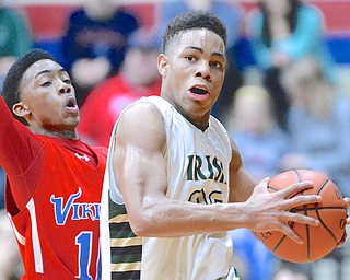 Jeff Lange | The Vindicator  Ursuline's David Collins (right) drives to the basket around VASJ's Vaughn Johnson during first half action of their regional championship game, Saturday night in Canton.