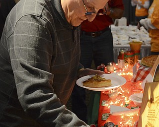 Katie Rickman | The Vindicator.Sam Fiumara of Poland helps himself to a napkin after picking out a slice of pizza from Belleria during the Mahoning Valley Pizza Cook-Off benefit for Potential Development Schools at Mr. Anthony's in Boardman on Sunday, March 8, 2015.