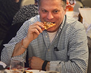 Katie Rickman | The Vindicator.Todd Marian of Poland takes a bite of pizza during the Mahoning Valley Pizza Cook-Off benefit for Potential Development Schools at Mr. Anthony's in Boardman on Sunday, March 8, 2015.