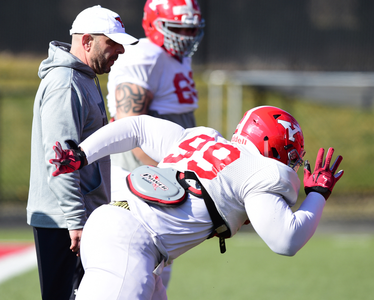 YOUNGSTOWN, OHIO - MARCH 24, 2015: Defensive line coach Carl Pelini watches as defensive linemen Fazson Chapman #99 comes off the ball during individual position drills during Tuesday afternoons practice at Stambaugh Stadium. (Photo by David Dermer/Youngstown Vindicator)