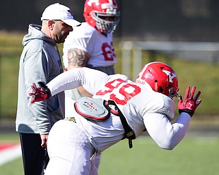 YOUNGSTOWN, OHIO - MARCH 24, 2015: Defensive line coach Carl Pelini watches as defensive linemen Fazson Chapman #99 comes off the ball during individual position drills during Tuesday afternoons practice at Stambaugh Stadium. (Photo by David Dermer/Youngstown Vindicator)