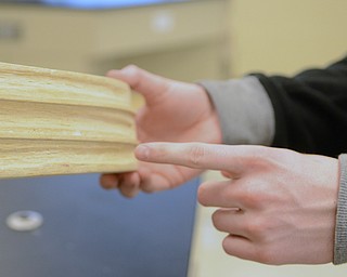 Katie Rickman | The Vindicator.Jarrod Kegley points to grooves that they made on their boat that they made for a physics competition. Kegley said the grooves eliminated resistance and caused the boat to move faster.