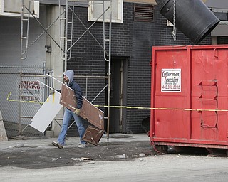        ROBERT K. YOSAY  | THE VINDICATOR..The Legal Arts Building - and The Hub Restaurant  on Market and Boardman felt the ravages of winter as a roof drain pipe froze sending water throughout the building. A worker caries wet drywall to  a dumpster