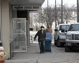        ROBERT K. YOSAY  | THE VINDICATOR..The Legal Arts Building - and The Hub Restaurant  on Market and Boardman felt the ravages of winter as a roof drain pipe froze sending water throughout the building. A worker caries wet drywall to  a dumpster