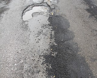        ROBERT K. YOSAY  | THE VINDICATOR..Like a kniting saying..  Knit one / pearl two... county workers seem to fix one pothole on S. Turner Near Mahoning.. but.. yes left others empty.....Day-reporting inmates supervised by Mahoning County deputies will once again help the county engineerÕs crews patch potholes..This year, however, the work will be done with the consent of Teamsters Union Local 377, which represents the county engineerÕs road maintenance employees.
