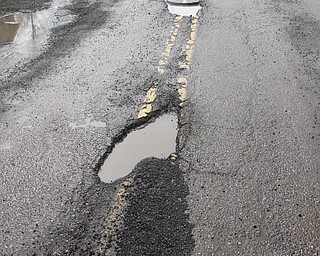        ROBERT K. YOSAY  | THE VINDICATOR..Like a kniting saying..  Knit one / pearl two... county workers seem to fix one pothole on S. Turner Near Mahoning.. but.. yes left others empty.....Day-reporting inmates supervised by Mahoning County deputies will once again help the county engineerÕs crews patch potholes..This year, however, the work will be done with the consent of Teamsters Union Local 377, which represents the county engineerÕs road maintenance employees.