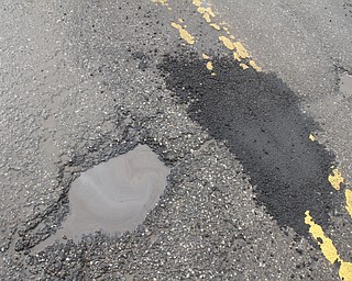        ROBERT K. YOSAY  | THE VINDICATOR..Like a kniting saying..  Knit one / pearl two... county workers seem to fix one pothole on S. Turner Near Mahoning.. but.. yes left others empty.....Day-reporting inmates supervised by Mahoning County deputies will once again help the county engineerÕs crews patch potholes..This year, however, the work will be done with the consent of Teamsters Union Local 377, which represents the county engineerÕs road maintenance employees.