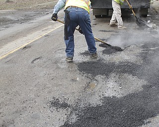        ROBERT K. YOSAY  | THE VINDICATOR..filling and leveling are Coy Serdich and Abe Hammond with Mahoning County Engineers on Indianola Rd in Boardman..Day-reporting inmates supervised by Mahoning County deputies will once again help the county engineerÕs crews patch potholes..This year, however, the work will be done with the consent of Teamsters Union Local 377, which represents the county engineerÕs road maintenance employees.