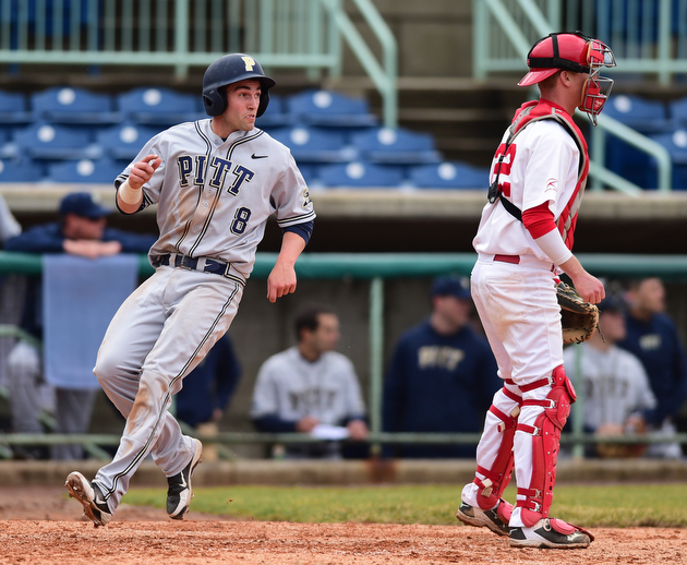 NILES, OHIO - MARCH 25, 2015: Eric Hess #8 of Pitt crosses home plate to score the 7th Pitt run of the game  behind catcher Jonny Miller #22 of YSU in the top of the 4th inning during Wednesday afternoons game at Eastwood Field. (Photo by David Dermer/Youngstown Vindicator)