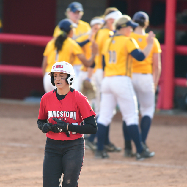 YOUNGSTOWN, OHIO - MARCH 25, 2015: Base runner Miranda Castiglione #17 of YSU walks to the dugout after grounding out to end the ball game while Kent State players celebrate behind her after game 1 of a doubleheader Wednesday night at the YSU Softball Complex. (Photo by David Dermer/Youngstown Vindicator)