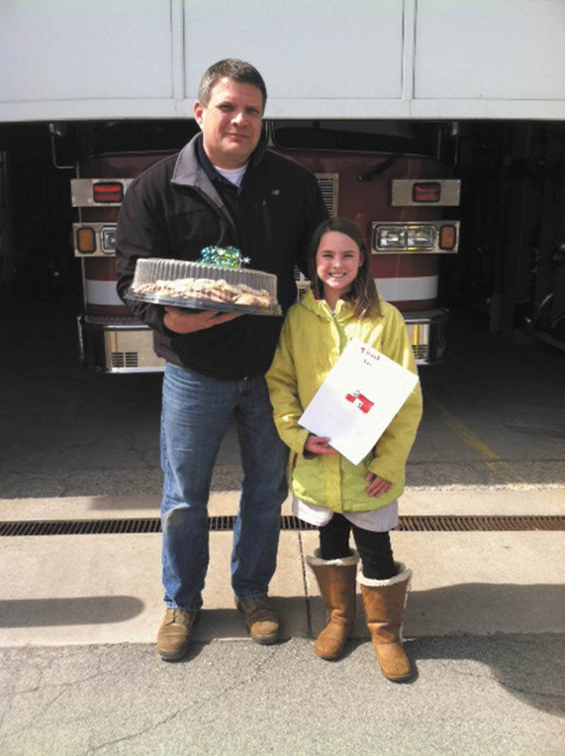 SPECIAL TO THE VINDICATOR: St. Patrick School in Hubbard participated in a day of service March 19 to show appreciation and care for the community. Each grade performed a different service project. The fourth-grade class baked cookies for the city of Hubbard’s safety forces. Above, fourth-grader Nicolette Leonard presented Fire Chief Ron Stanish of the Eagle Joint Fire District with a tray of cookies and a card signed by the students to thank firefighters for their service to the community. At the end of the day, all students met to spring clean the building and church grounds. 