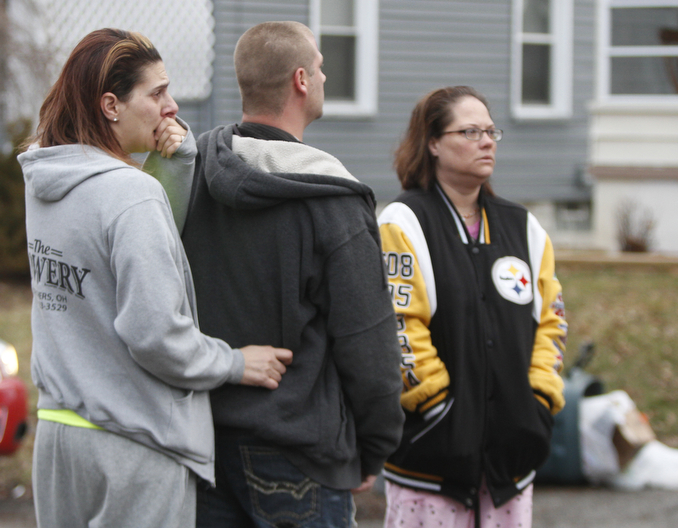        ROBERT K. YOSAY  | THE VINDICATOR..Neighbors  stare quietly at the house where 3 people died on Powers Way  in Youngstown ....YFD, Mahoning Valley Arson Task Force, YPD detectives and State Fire Marshalls office as they investigated a fatal fire that killed Two grandparents and their 11 year old grandaughter.