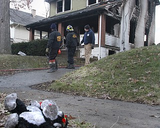William D Lewis The Vindicator Fire personel investigate a fire where 3 people died as a stuffed animal on the ground near a Powerwsway housefire where 3 people died including a young girl. 3-30-15.