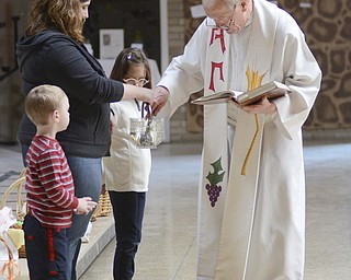 Katie Rickman | The Vindicator.Rev. Timothy O'Neill gets Holy Water from Tricia Morgan of Girard as Clark McAllen 4 of Hubbard and Aubrey Munnell 7 of Hubbard watch during the Easter Basket Blessing Ceremony at St. Patricks Church in Hubbard on April 4, 2015. The three helped the Rev. during the ceremony.