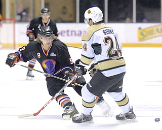 Jeff Lange | The Vindicator  APRIL 4, 2015 - Youngstown's Taylor Best (9) passes the puck to a teammate around the defense of Lumberjacks' Ryan Siroky in the second period of the Phantoms' game, Saturday night at the Covelli.