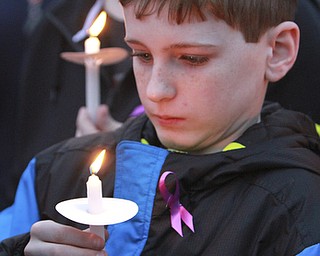 William D Lewis The vindicator Joseph Mullarkey, 11, of Youngstown holds a candle during a 4-7-15 vigil for 3 people who died in a Youngstown house fire.