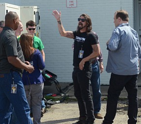Katie Rickman | The Vindicator .Foo Fighters front man Dave Grohl waves at fans after arriving at the Pine Tree Place Shopping Center in Niles to perform for a lucky group of fans who waited in line over night at The Record Connection days before.  The Foo Fighters performed in honor of National Record Store Day.