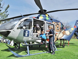 Jeff Lange | The Vindicator  APRIL 18, 2015 - Vincent Polakovitch, age 4, of Canfield (center) gets assistance getting out of the helicopter from an Akron Children's Hospital pilot, Saturday morning at Fellows Riverside Gardens in Youngstown during the 9th annual Children's Book Festival.