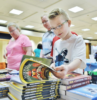 Jeff Lange | The Vindicator  APRIL 18, 2015 - 9 year old Kyle Miller of Youngstown flips through the pages of a National Geographic book, Saturday at Fellows Riverside Gardens in Youngstown during the 9th annual Children's Book Festival.