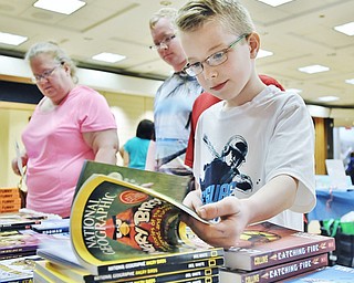 Jeff Lange | The Vindicator  APRIL 18, 2015 - 9 year old Kyle Miller of Youngstown flips through the pages of a National Geographic book, Saturday at Fellows Riverside Gardens in Youngstown during the 9th annual Children's Book Festival.