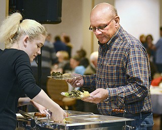 Katie Rickman | The Vindicator.Dylann Morrison of Girard (on left) serves food from the Fire Grill to Gary Clayman of Liberty at the Memorable Meals Mahoning Valley at the Stambaugh Auditorium on April 26, 2015.