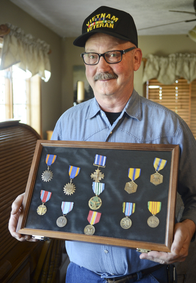 Norm Paul holds a shadow box full of medals he earned for his service in the Air Force, he recently was inducted into the Ohio Military Hall of Fame for Valor.