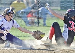 Jeff Lange | The Vindicator  APRIL 29, 2015 - Canfield's Kara Rothbauer (32) slides safely into third under the tag of Champion's third baseman Brittany Allen in the bottom of the third inning of their softball game at Canfield High School, Wednesday night.