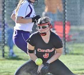 Jeff Lange | The Vindicator  APRIL 29, 2015 - Canfield's third baseman Karina Kennedy stops a ground ball sent up the third baseline as Champion's Amber Ricci looks on from behind during fifth inning action at Canfield, Wednesday night.