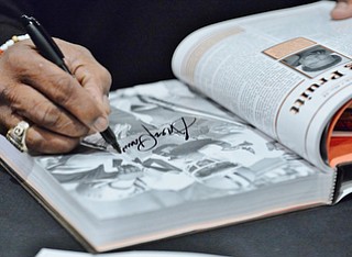 Jeff Lange | The Vindicator  APRIL 25, 2015 - 5-time Pro Bowl running back and former Cleveland Brown, Greg Pruitt, autographs a page in a book for a fan during Saturday's meet and greet at Firebirds in Niles.