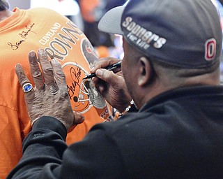 Jeff Lange | The Vindicator  APRIL 25, 2015 - 5-time Pro Bowl running back and former Cleveland Brown, Greg Pruitt, signs the back of life-long Browns fan Robert Stevens' shirt during Saturday afternoon's meet and greet with a few members of the 1980 Cleveland Browns at Firebirds in Niles. Stevens is from Warren.