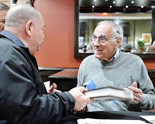 Jeff Lange | The Vindicator  APRIL 25, 2015 - Coach of the 1980 Cleveland Browns Sam Rutigliano (right) shares a moment with Bill Springer of Cortland after signing his book during Saturday's meet and greet at Firebirds Grill.