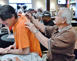 Jeff Lange | The Vindicator  APRIL 25, 2015 - Kicker for the 1980 Browns Don Cockroft (right) signs the back of Robert Stevens of Warren during Saturday afternoon's autograph signing at Firebirds.