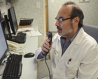 Katie Rickman | The Vindicator.Dr. Marc Saunders DO speaks into the Dragon medical device that dictates notes for him into a computer at St. Joseph's in Warren on May 5, 2015.