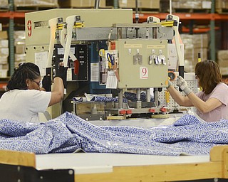 Katie Rickman | The Vindicator.Ruth Johnson of Youngstown, on left, and Vicki Robinson of Howland work on a RF Heat Sealing machine atGLI Pool Products in Youngstown on May 5, 2015.