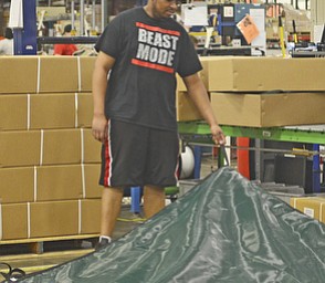 Katie Rickman | The Vindicator.Maurice Smith of Youngstown folds up a pool cover at GLI Pool Products in Youngstown on May 5, 2015. GLI recently won several awards for having minimal safety incidents.