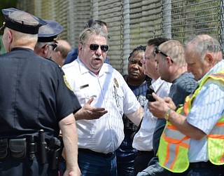 Jeff Lange | The Vindicator  MAY 4, 2015 - Deputy Chief for Mahoning County Hazmat Sil Caggiano (left center) discusses the progress of the leak with police, Monday morning just outside the waste water treatment plant in Youngstown.